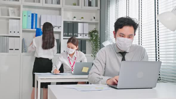 Asian attractive business people wear face mask and working in office. alt