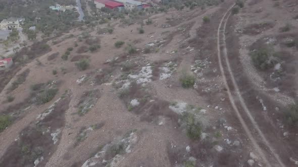 Aerial view of a hillside in Arraba Palestine Middle East with warehouse in the background alt