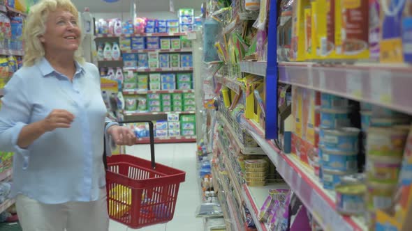 Senior Woman Buying Pet Food in the Store alt