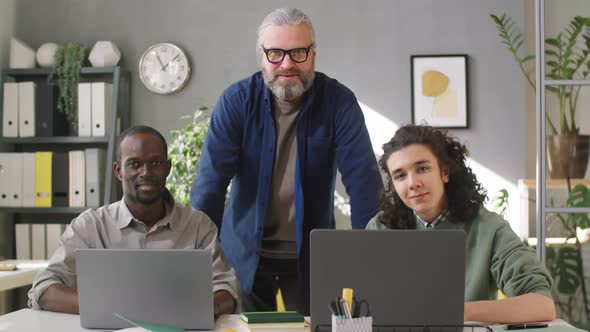 Portrait of Senior Business Mentor and Young Multiethnic Trainees in Office alt