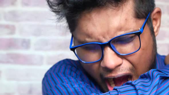 Young Ill Man Covering Her Nose and Mouth with Arm. alt