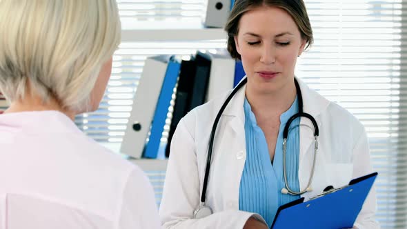 Female doctor interacting over a report with a patient alt