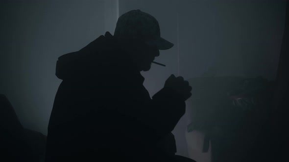 Silhouette Of A Man Lighting A Cigarette alt