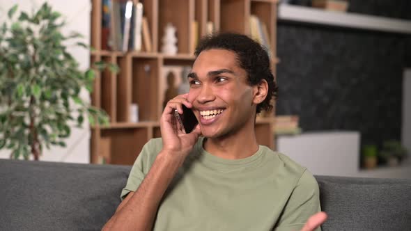 Smiling and Positive Multiracial Guy in Casual Shirt Talking By the Smartphone