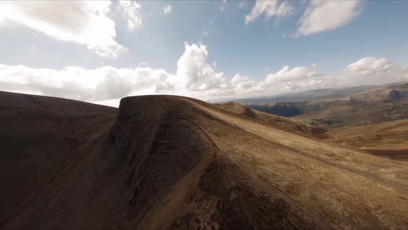 FPV Drone Footage Smooth Stabilized Fly Along Mountain Rocky Hill Around Highland Lake alt