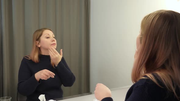 Woman Applies Skincare Cream