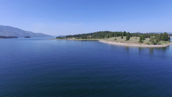 Camera flies low over Jackson Lake and then ascends as it approaches shore alt