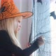 Happy Girl in Witch Costume Preparing for Halloween Decorating Window in Room By Black Bats - VideoHive Item for Sale