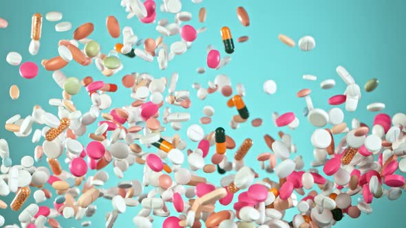 Super Slow Motion Shot of Flying Colorful Pills on Light Blue Background at 1000Fps alt