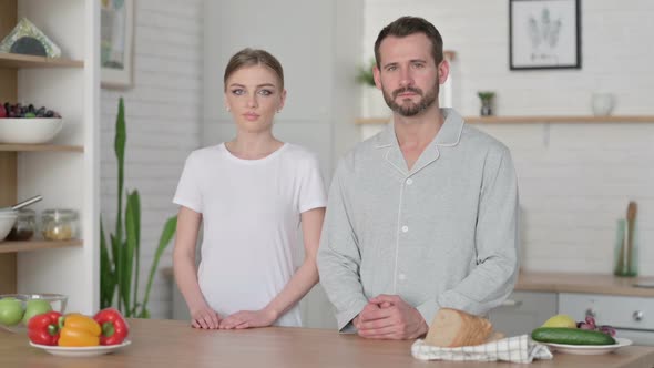 Young Woman and Man Looking at Camera in Kitchen alt