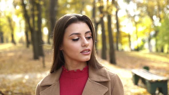 Passionate Look Into Camera of Brunette with Brown Eyes During a Walk in Park alt