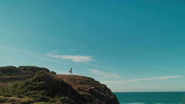 Woman Stand on Edge of Ocean Cliff with Phone