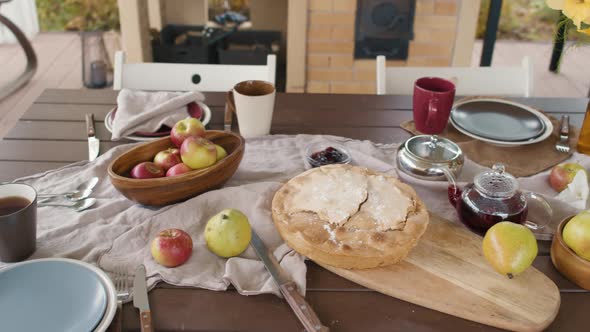Wooden Table Full of Food on Outdoor Terrace alt
