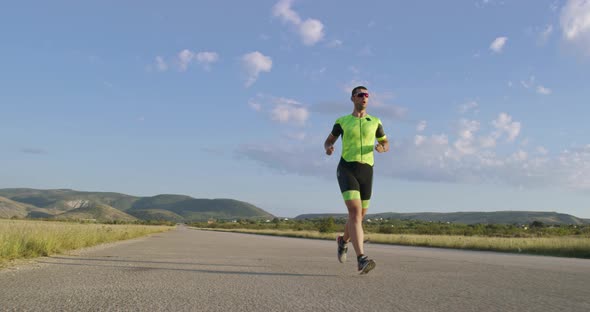 Triathlon  Male Triathlete Running in Triathlon Suit Training for Ironman Race alt