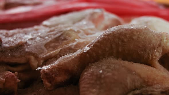 Closeup View of Hands in Gloves Packing Chicken Legs From a Box Into Individual Plastic Bags alt