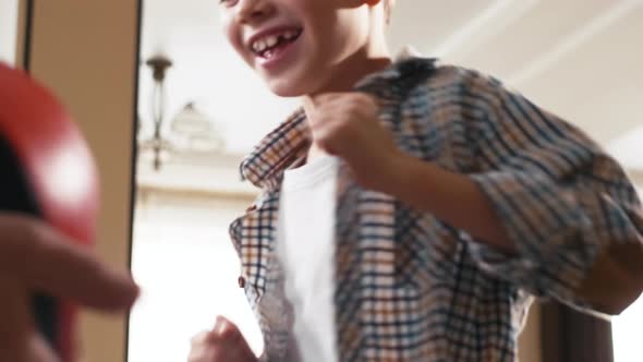 Caucasian boy trying to fight with punching bag