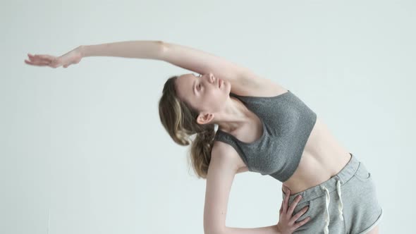 Young Fit Sporty Slim Girl in Sportswear Does Exercises Leaning and Stretching alt