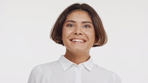 Young Beautiful East Asian Female in Shirt Suprisingly Smiling Twice on White Background alt