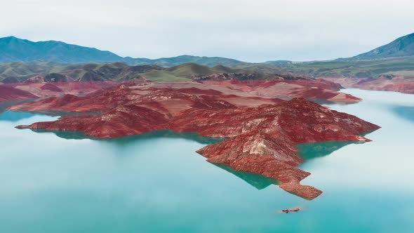 Amazing Aerial Landscape Over a Rocky Shore of Red Stone and Sand By a River with Clear Turquoise alt
