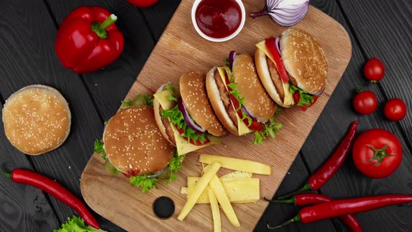 Vegetarian Burgers on a Wooden Board with Different Vegetables Ketchup and Cheese alt