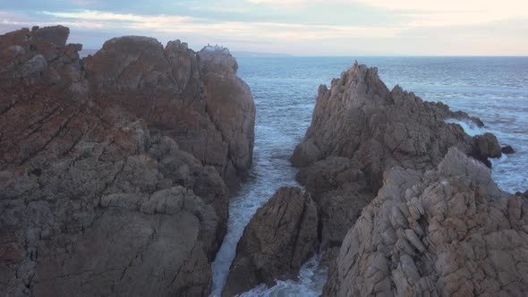 Aerial over a rocky coastline with waves breaking