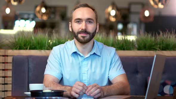 Portrait of Attractive Smiling European Young Bearded Businessman Looking at Camera alt