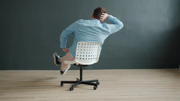 Smiling Guy Spinning On Office Chair Pointing At Camera Dark Smiling Guy Spinning On Office Chair