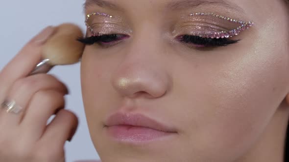 A Professional Makeup Artist Applies a Concealer Blush with a Special Brush to the Face of a Young alt