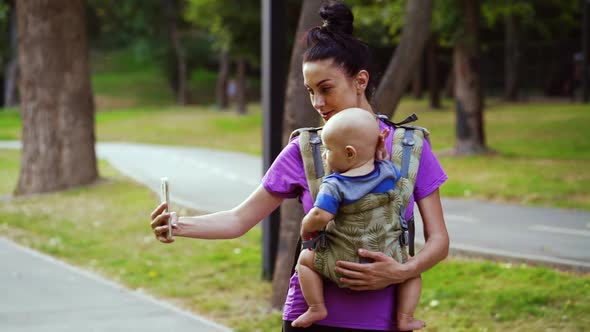 Woman with Baby Recording Video for Blog About Parenting alt