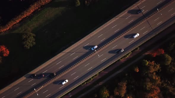 4K AERIAL: Cars and semi truck driving on busy highway across the country in beautiful autumn evenin alt