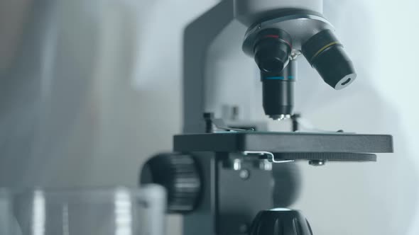 Virologist or Scientist is Looking Into Microscope alt