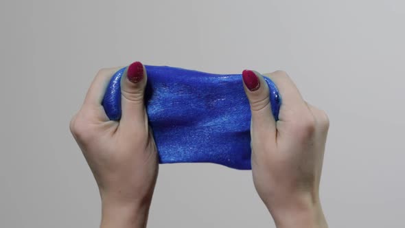 Woman Hands Playing with Oddly Satisfying Blue Slime Gooey Substance. Antistress alt