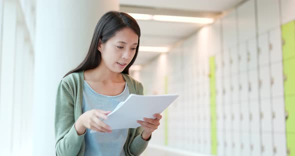 Young Woman reading on the note at school alt