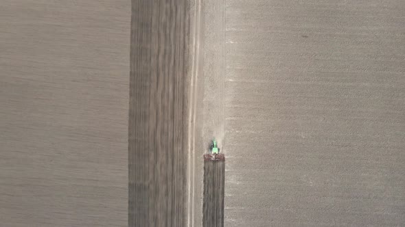 Top View Of Agricultural Industrial Tractor Plows Soil Field For Sowing