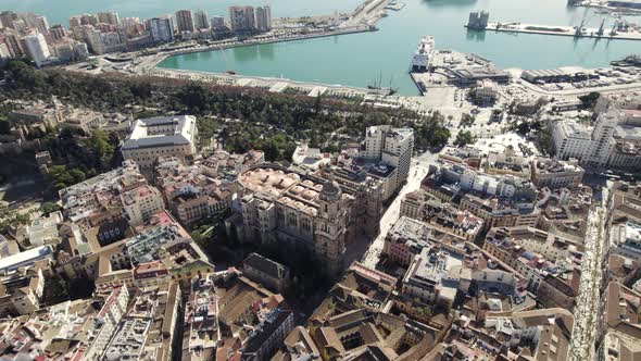 Malaga Cathedral against the city Port and seascape, Spain. Aerial wide pullback shot