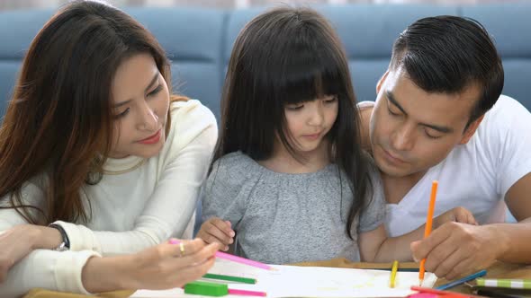 child female daughter homework and laugh together with parent in living room house concept alt