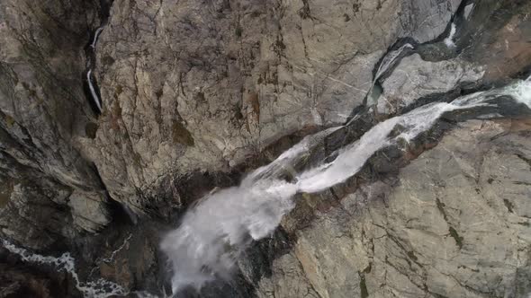 Slow-motion Aerial Shot of a Waterfall. Water Flowing Down on Rocks