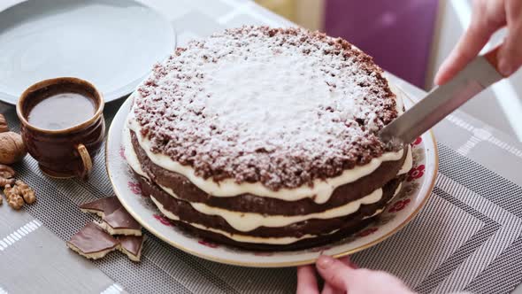 Woman Cutting A Delicious Slice Of Homemade Chocolate Cake alt
