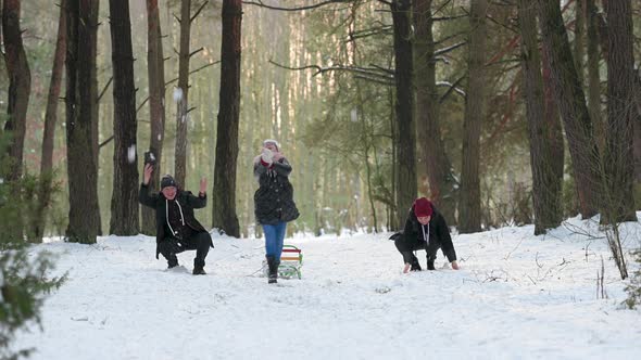 Family of three enjoying winter day in forest.