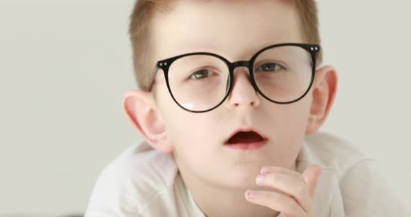 a little boy has a headache, holds his head with his hands. Portrait of caucasian 7 years old boy 