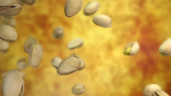 Closeup of Salted Pistachios Flying Diagonally on a Yellow Ochre Background alt