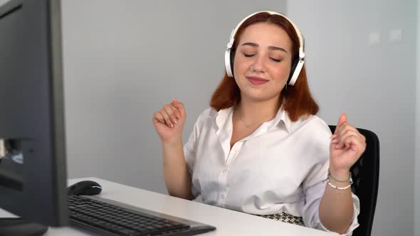 Woman Listening to Music While Working on Computer in the Office 4K alt