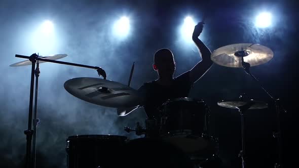 Energetic Music in the Performance of a Professional Drummer, Black Smoky Background, Silhouette alt