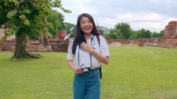 Asian backpacker blogger woman casual with camera walking smiling traveling around pagoda.
