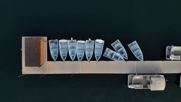 Aerial view looking down on boats tied to a dock on a warm summer evening. alt