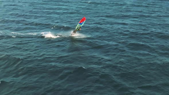 4k slow motion drone shot of windsurfer doing a looping in Guincho, Portugal. alt