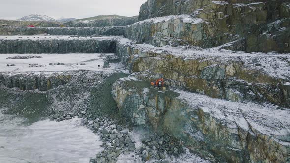 Excavator digging and throwing rocks. Flinstone work by Tracked vehicle. Snowy alt
