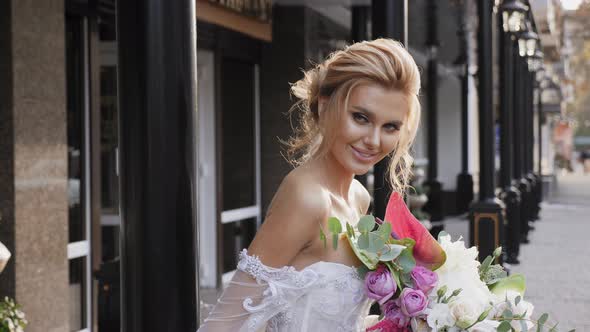 Portrait of a Beautiful Bride with a Bouquet in the City