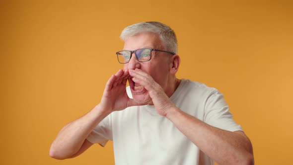 Mature Elderly Man Screaming Loud Against Yellow Background