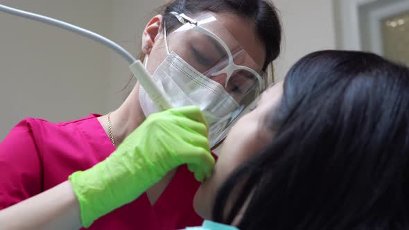 Woman at the Dental Hygienist Getting Professional Tooth Whitening and Ultrasound Cleaning alt